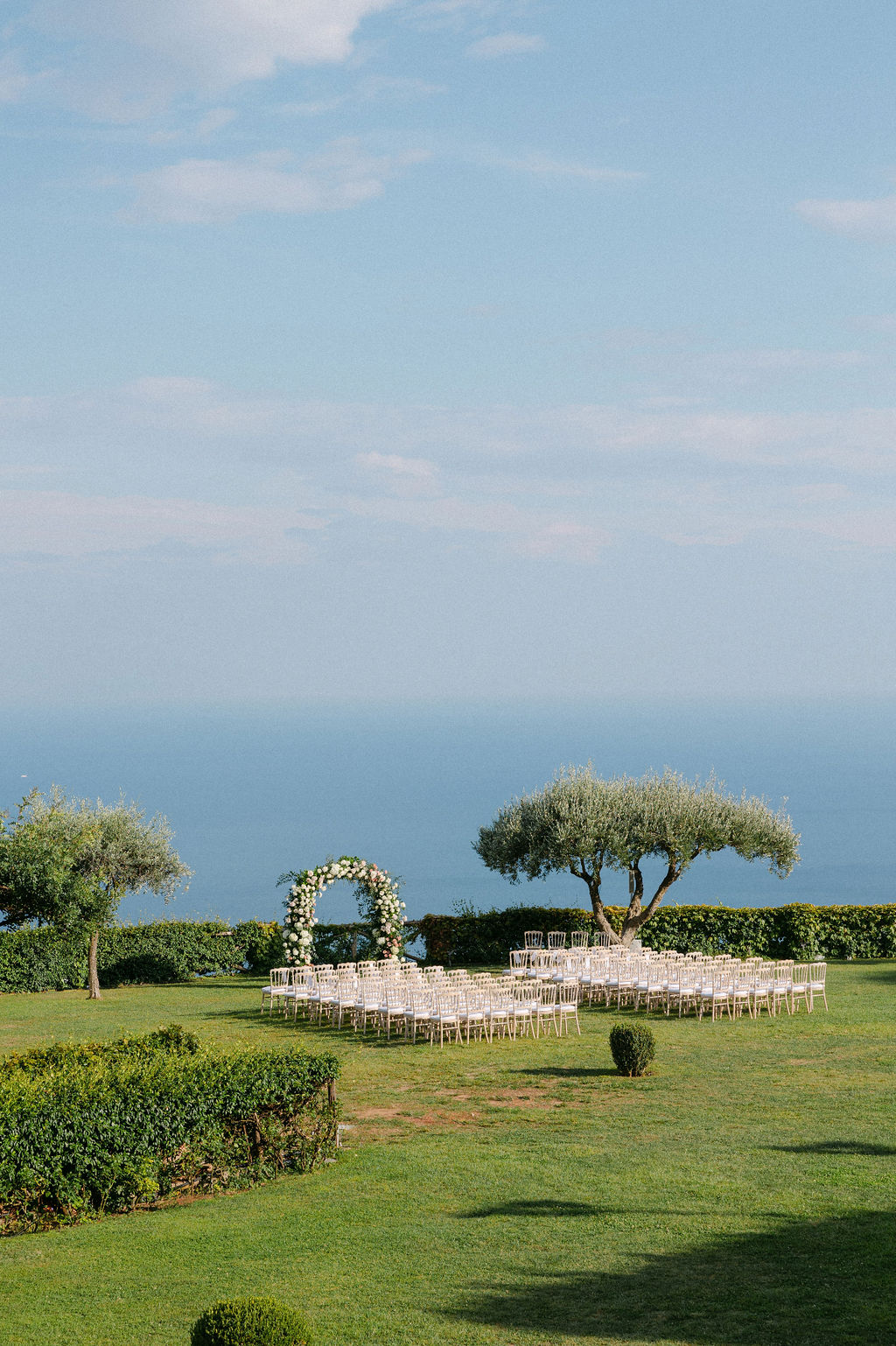 Garden of Villa Cimbrone with wedding ceremony setting with chairs and flowers arch